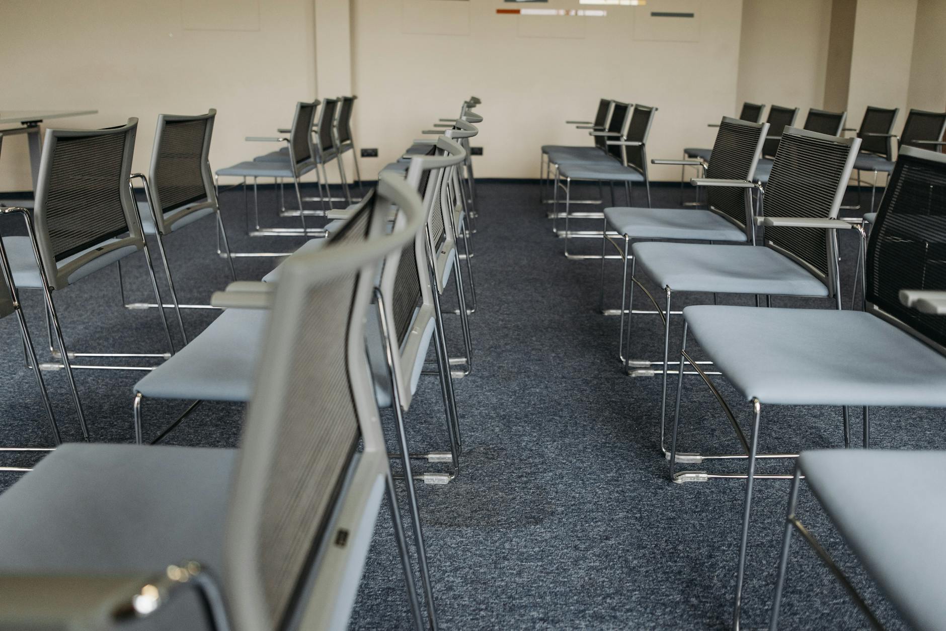 Pusta sala szkoleniowa z rzędami krzeseł na wykładzinie