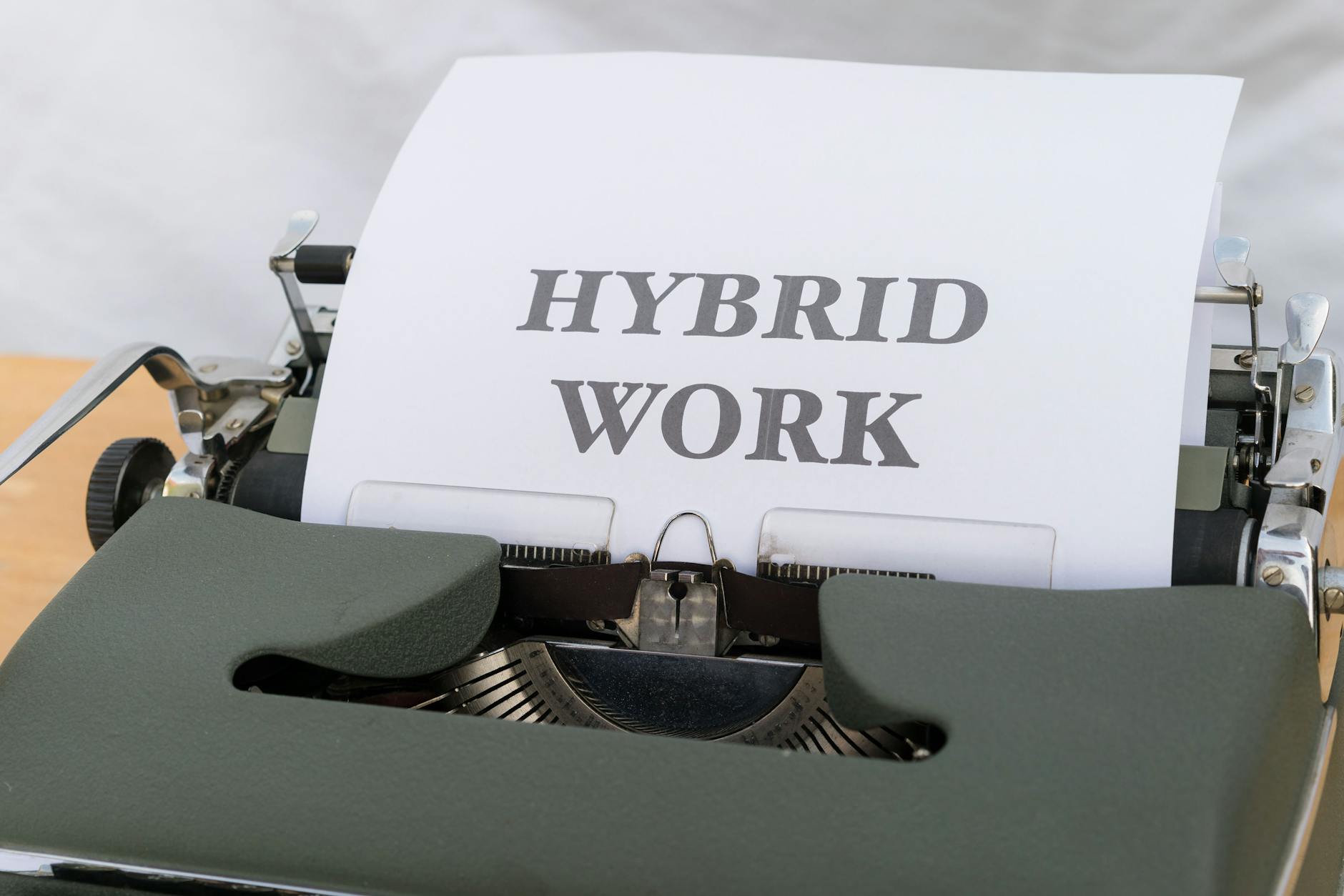 Zbliżenie na maszynę do pisania z napisem Hybrid Work na kartce