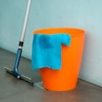 Zbliżenie na wiadro, mop i niebieską szmatkę do czyszczenia podłogi