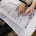 Inwestor i projektant analizują plany techniczne podłóg obiektowych