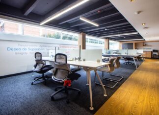 Płynne przejście między LVT a wykładziną dywanową. 5 pomysłów na strefowanie open space bez listew progowych Nowoczesne biuro z ergonomicznymi krzesłami i szklanymi ściankami